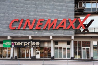 Kiel, Almanya - 17. Ekim 2025: Cinemaxx ve Enterprise Kiel, Almanya 'da modern bir blok binasında kiralık araba tabelası