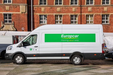 Kiel, Almanya - 17. Ekim 2025: Avrupalı kiralık minibüs, yeşil logosunu gösteriyor, kırmızı tuğla bir binanın önünde park halinde.