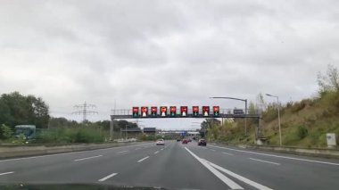 Hamburg, Almanya - 24. Ekim 2025: Hamburg yakınlarındaki Alman otobanı A7 'de dijital trafik ışığı altında araba kullanma