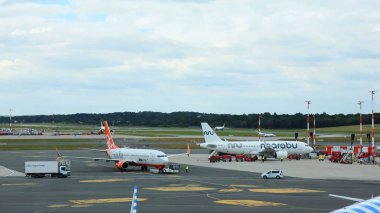 Hamburg, Almanya - 19. Eylül 2025: Havaalanı apronuna park etmiş yolcu uçakları yer mürettebatıyla birlikte uçuşlara hazırlanıyor