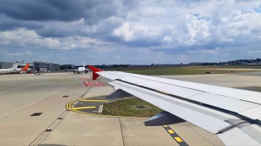 Hamburg, Almanya - 19. Eylül 2025: Bulutlu bir gökyüzünün altındaki uçak kanadı ve uçakları