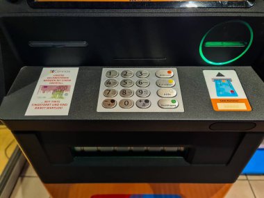 Kiel, Almanya - 05. Kasım 2025: Otomatik veznedar klavye ve kart okuyucusuna güvenlik uyarısı ile yakın plan