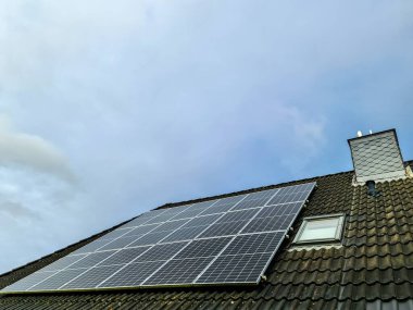 Güneş panelleri meskun bir çatıya kurulur güneş ışığını toplar ve onu ev enerjisi üretimi için yenilenebilir, sürdürülebilir ve çevre dostu elektriğe çevirir.