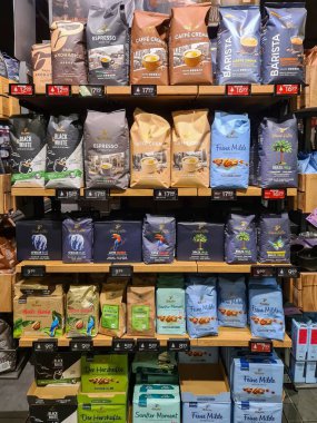 Kiel, Almanya - 24. Kasım 2025: Tchibo kahve poşetleri ve paketler ahşap süpermarket raflarında düzenli olarak düzenlenerek, alışverişçiler için çeşitli perakende seçimleri sergileniyor