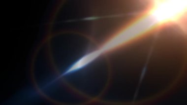 Warm, cinematic optical lens flare moving smoothly across a black background, creating shimmering light rays and colorful bokeh, ideal for overlays, transitions, and motion graphic effects