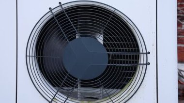 Çağdaş havanın su ısıtma pompasına yakın görüntüsü pervaneli pervaneler dönmeye başlıyor, verimli enerji tüketimini teşvik ediyor ve evler için yenilenebilir ısıtma çözümleri sunuyor.