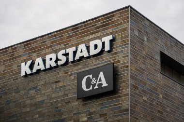 Kiel, Almanya - 01. Aralık 2025: Almanya 'nın Kiel kentindeki çağdaş bir binanın ön cephesinde, Karstadt ve C & A adlı iki tanınmış Avrupa mağazasının tabelaları