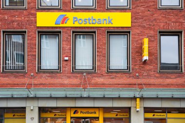 Kiel, Almanya - 01. Aralık 2025: Almanya 'nın Kiel kentindeki bir ticaret binasında kırmızı tuğla cepheli ve belirgin tabelalı posta şubesi