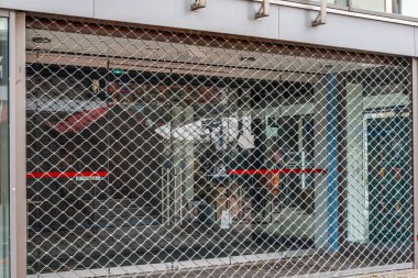 Kiel, Almanya - 01. Aralık 2025: Metal güvenlik ızgarası, Almanya 'nın Kiel kentindeki bir caddede mağaza girişini kapatarak yıkıldı. İş bitirme kavramı