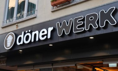 Kiel, Almanya - 13. Aralık 2025: WERK Restoran tabelasında stilize olmuş dner kebab logosu bina cephesinde 