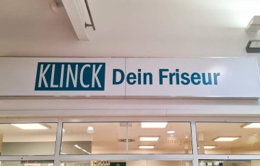 Flensburg, Almanya - 20. Aralık 2025: Bir Alman kuaför salonu için açık tabela, marka adı ve hizmet sergileniyor