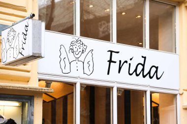 Flensburg, Almanya - 20. Aralık 2025: Bir karikatür melek figürünün yer aldığı Frida mağaza tabelası perakende şirketi cephesi