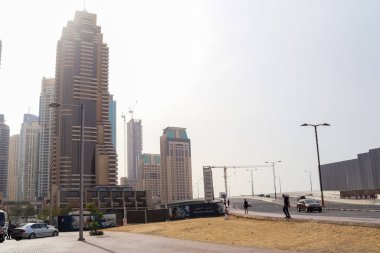 Dubai, Birleşik Arap Emirlikleri - 24. Eylül 2024: Dubai Marina, gökyüzü altında yüksek konut binaları, devam eden inşaat ve şehir yaşamını gösteriyor