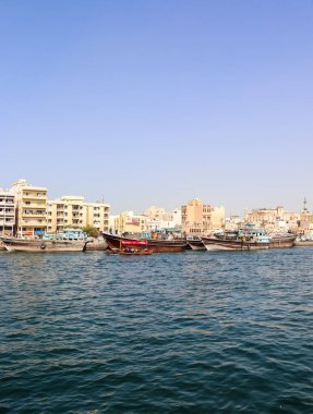 Dubai, Birleşik Arap Emirlikleri - 24. Eylül 2024: Geleneksel dalışlar Dubai Deresi boyunca canlı bir şehir manzarası oluşturan tarihi binalarla kenetlendi