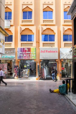 Dubai, Arap Emirlikleri - 26. Eylül 2025: Geleneksel mimari, dükkan önleri ve yürüyen ve oturan insanların yer aldığı yaya sokağı