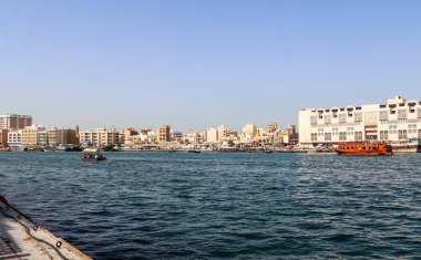 Dubai, Arap Emirlikleri - 26. Eylül 2025: Dubai Deresi tarihi şehir binalarında gezinen geleneksel abra botlarını gösteriyor