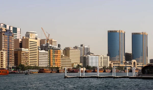 Dubai, Arap Emirlikleri - 26. Eylül 2025: Dubai Creek limanı kentsel ufuk çizgisini, geleneksel tekneleri ve ticari binaları gösteriyor
