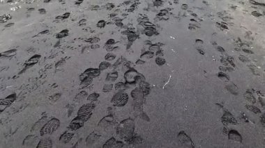 İzlanda 'nın ünlü sahilinin karanlık volkanik kumlarında ayak izleriyle yürüyen ilk kişi.