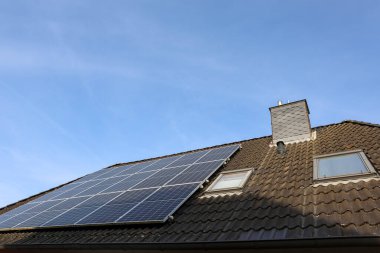 Bir evin çatısındaki güneş panelleri sürdürülebilir enerji için güneş ışığını yakalıyor