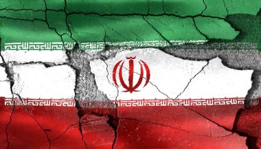 Parçalanmış, çatlamış beton yüzeyde İran bayrağı siyasi huzursuzluk ve ekonomik istikrarsızlığı temsil ediyor