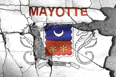 Hasarlı ve çatlak duvar yüzeyine boyanmış Mayotte arması.