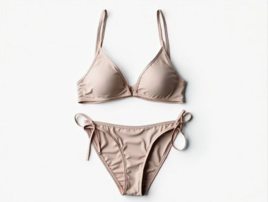 Beyaz arka planda duran bej bikini modeli, yaz moda tasarımlarını sergilemek için mükemmel.