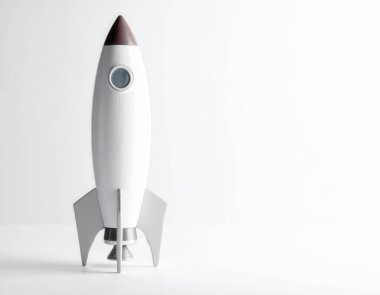 Beyaz arka planda duran beyaz ve gri oyuncak roketi, iş büyümesini, teknolojiyi ve başarıyı simgeliyor