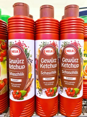 Kiel, Almanya - 28. Ocak 2026: Şaşlık aroması için kırmızı HELA baharatlı ketçap şişeleri perakende rafında duruyordu