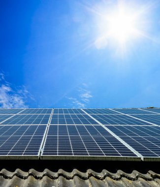 Çatıdaki güneş panelleri yenilenebilir elektrik üretimi için güneş ışığı topluyor.