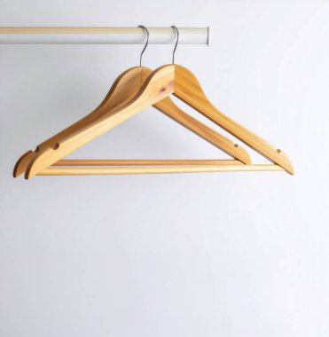 Ahşap elbise askıları boş, temiz bir dolabın içinde asılıydı. Minimalizm, organizasyon ve düzeni temsil ediyordu.