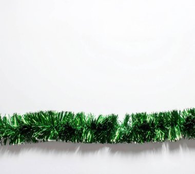 Yeşil çelenk, bayram dekorasyonu ve Noel kutlamaları için beyaz bir arka planda bayram sınırı oluşturuyor.