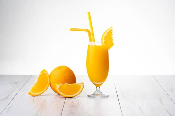 Orange juice and piece of orange on white background