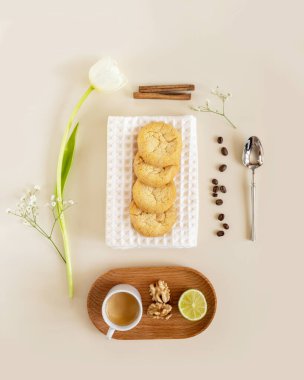 Çevre dostu, sabah, ev yapımı narenciye kurabiyeli yemek kompozisyonu, bir fincan espresso, kahve çekirdekleri ve arka planda lale. Evde dinlenmek, el yapımı düşük karbonhidrat pişirme, kahve zamanı. Üst görünüm