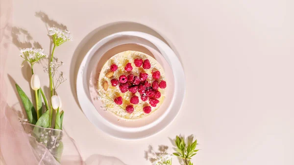 Food composition with raspberry almond cake with and spring bouquet with tulips on a pink background. Sweet pastries with almond flour are gluten-free, low in carb. Keto diet. Healthy dessert