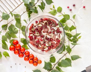 Soğanlı biftek, ızgarada mevsimlik sebzeler ve beyaz arka planda huş dalları.