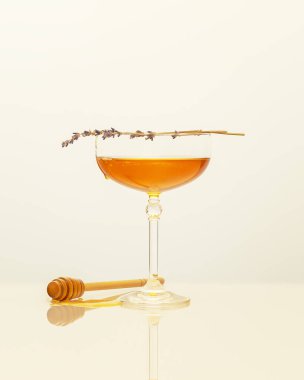 Bağışıklık arttırıcı gıda. Cam bardakta sıvı bal, lavanta filizi ve beyaz arka planda bal kapağı içeren sağlık sigortası bileşimi. Bağışıklık ve virüslere karşı doğal tedavi. Dikkatli bir yemek.