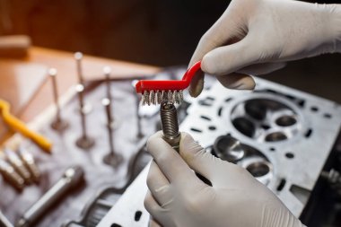 Otomobil tamircisi garajda çalışıyor. Tamir servisi. Otomobil motoru silindiri, bakım onarımı için otomobil servis istasyonunda açılır. 