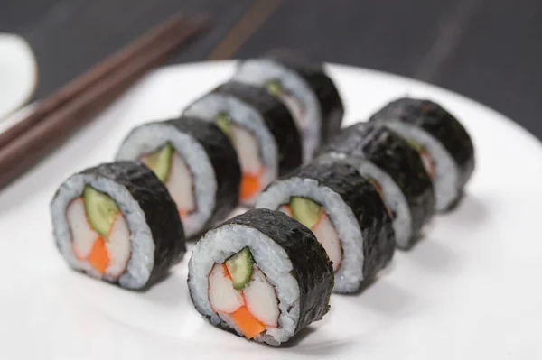 Sushi Rolls with shrimp on White background. Japanese traditional roll with prawn. Sushi set on a stone plate and dark concrete background. Sushi roll set and chopsticks. Fresh Japanese cuisine. asia