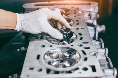 Otomobil tamircisi garajda çalışıyor. Tamir servisi. Otomobil motoru silindiri, bakım onarımı için otomobil servis istasyonunda açılır.