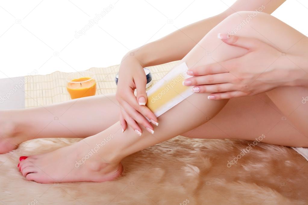 Girl doing depilation with wax on the feet.