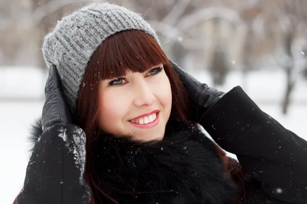 Beautiful girl in a snowy winter park — Stockfoto