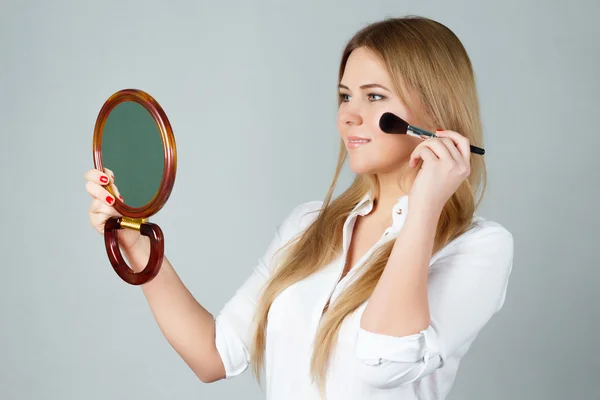 Pige gør make-up ser i spejlet - Stock-foto