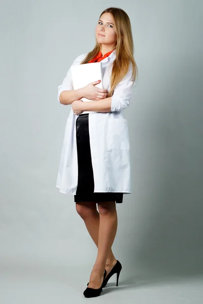 Beautician girl in a white robe with a tablet for papers. — Stock Photo, Image