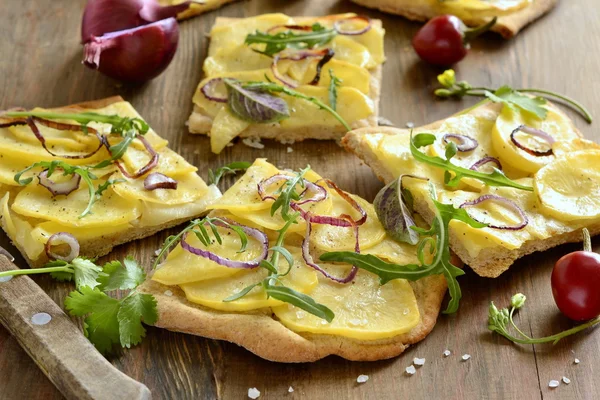 Pizza végétarienne aux pommes de terre, oignon rouge et légumes verts Images De Stock Libres De Droits