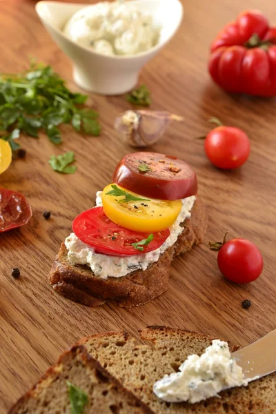 Panino di pane di segale con crema di formaggio, pomodori ed erbe aromatiche — Foto Stock