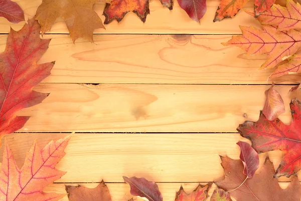 ใบไม้ร่วงบนพื้นหลังไม้ — ภาพถ่ายสต็อก