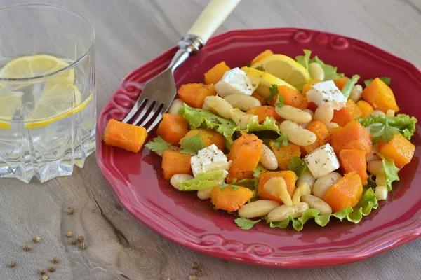 Салат с запечённой тыквой, белой фасолью и фета — стоковое фото
