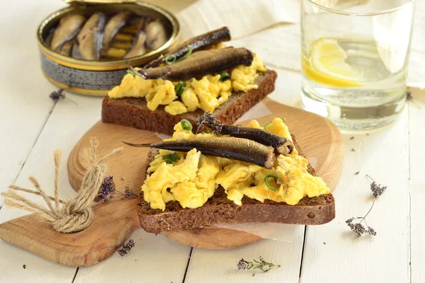 Sandwich with scrambled eggs and sprats — Stock Photo, Image