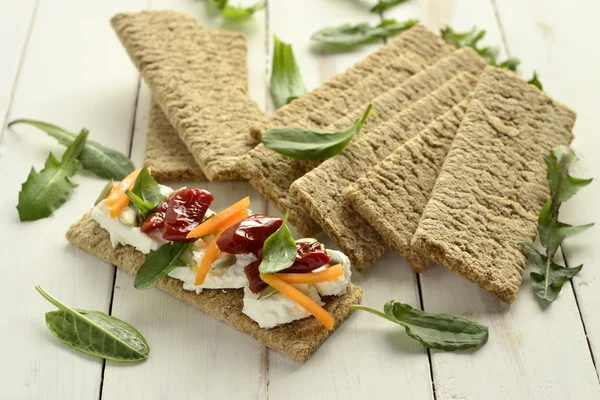 Pane croccante con crema di formaggio, pomodori secchi ed erbe aromatiche — Foto Stock