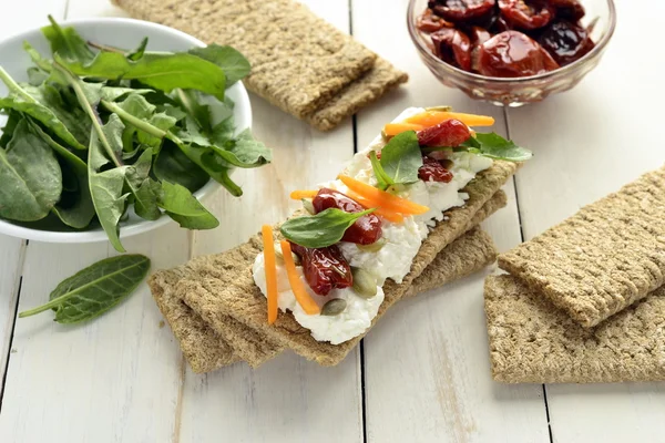 Pan crujiente con queso crema, tomates secados al sol y hierbas — Foto de Stock